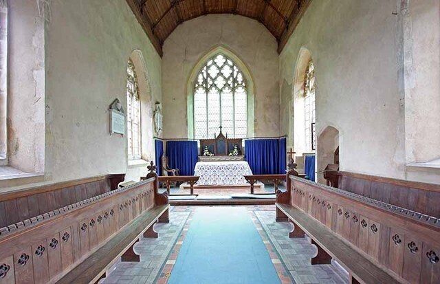 A church interior with arched windows, wooden pews, and a central altar.