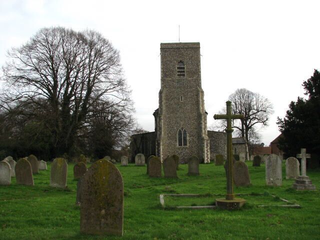 A church with a tall tower and a graveyard with numerous headstones.