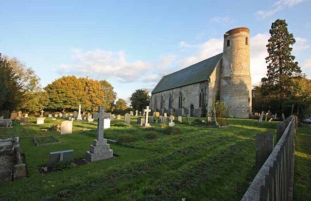 A church with a tower, surrounded by a cemetery with gravestones.