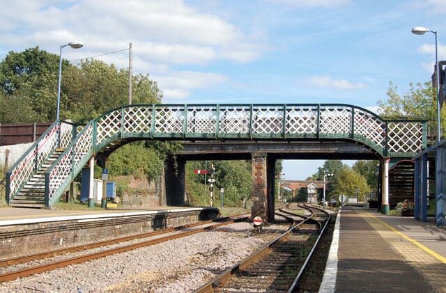 Reedham station photo-survey (12) Looking east along the up (Norwich-bound) platform in the down direction at Reedham railway station footbridge. Beyond the footbridge, a road bridge spans the station. The signal box is visible in the distance. Reedham station is on the ex-Great Eastern Rly route from Norwich to Lowestoft and is situated roughly mid-way between the two towns. Reedham station has two platforms, one for up (Norwich-bound) traffic and one for down (Yarmouth and Lowestoft) traffic. The majority of passenger services are operated by National Express. Half-a-mile east of the station is Reedham Junction; a single track route branches northeast to Yarmouth and the double track route continues southeast to Lowestoft. The junction is controlled by a traditional lever-frame signal box between the station and the junction itself.