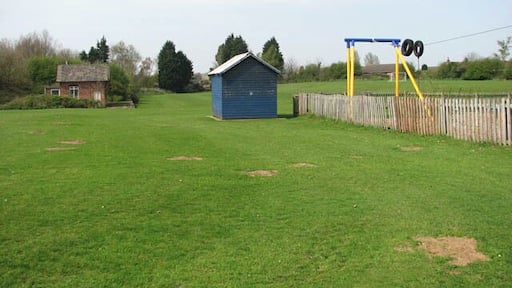 Corpusty - children's playground. The children's playground and adjoining football ground are located where once the railway station and goods yard used to be. Only the station building and a platform (seen in background at left) remain of the railway station and goods yard. The station, officially known as Corpusty & Saxthorpe, was a stop on the M&GN (Midland and Great Northern Joint Railway) route between Melton Constable and Great Yarmouth. The station was closed in 1959, the bridge > 1257349 is half filled-in and the trackbed removed. Some of it is buried under a playing field and some has been planted over > 1257355 - most of what remains is overgrown and impassable > 1257344. The villages Corpusty and Saxthorpe, situated either side of the river Bure, merge into each other. Each village has their own church but St Andrew's > https://www.geograph.org.uk/photo/309082 serves both villages ever since Corpusty's Saint Peter's > https://www.geograph.org.uk/photo/873327 - located on the outskirts of the village and separated from it by the busy B1149 - closed and came in the care of the Friends of Friendless Churches.