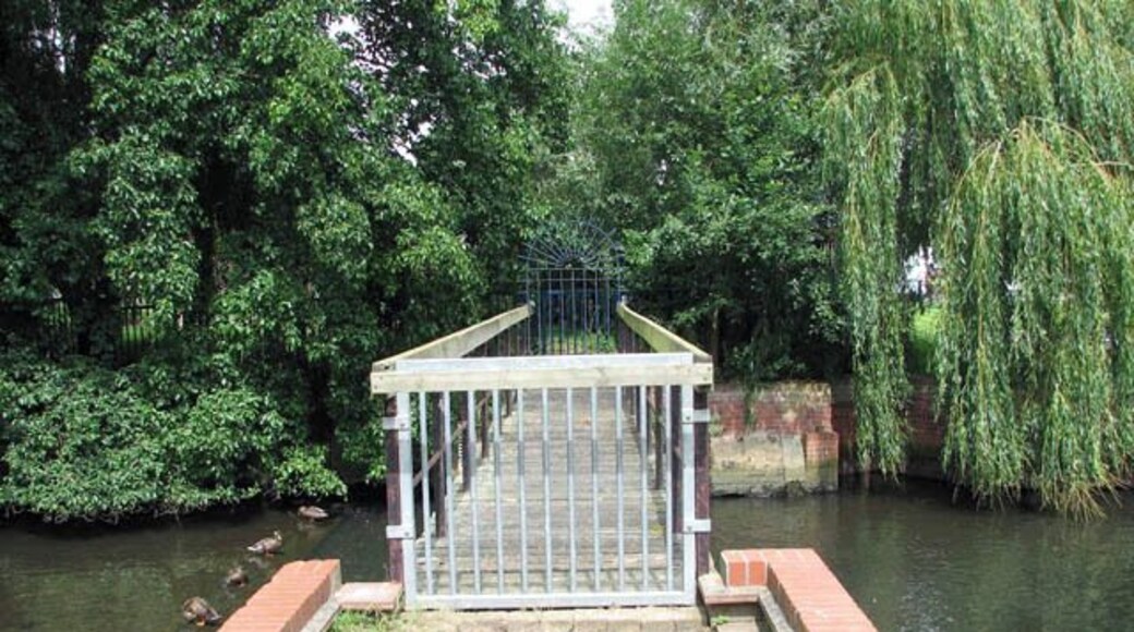 Footbridge with blocked access across the River Chet. Ducks are sitting above the weir to the left of the bridge. Loddon is a market town in the Broadland district in South Norfolk, located on the River Chet, where there is a marina and staithes once used by the wherries. The watermill > 1418845 by the bridge across the river is recorded to be the oldest building in the town. The town centre has been designated as a conservation area and is made up of many period properties > 1418870. Most of the village shops > 1418876 are situated along Bridge Street > 1418866 - the main thoroughfare, as is Holy Trinity church > 525219.