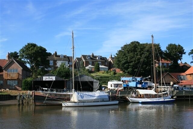 Boatyard, Reedham Seen from the wherry Hathor; near this point was the boatyard, Daniel Hall's, where the wherry was built in 1905. A sculpture and information board on the quay commemorate Reedham's boatbuilding history. The yacht on the left is a traditional Broads River Cruiser called Wisp, built by Jack Powles of Wroxham in 1934. She is moored outside Friend of all Nations, an old Yarmouth beach lifeboat, built in 1863. [Thank you to Wisp's owner for additional information.]