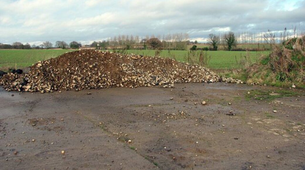 View north across cultivated field. The line of poplars seen in the background denote the course of King's Beck which flows into the River Bure a short distance further to the southeast. North Farm > 451507 - in adjacent grid square to the northwest - can just be glimpsed above the top of the heap of rubble which has been deposited at the edge of the concrete farm hardstand seen in the foreground.