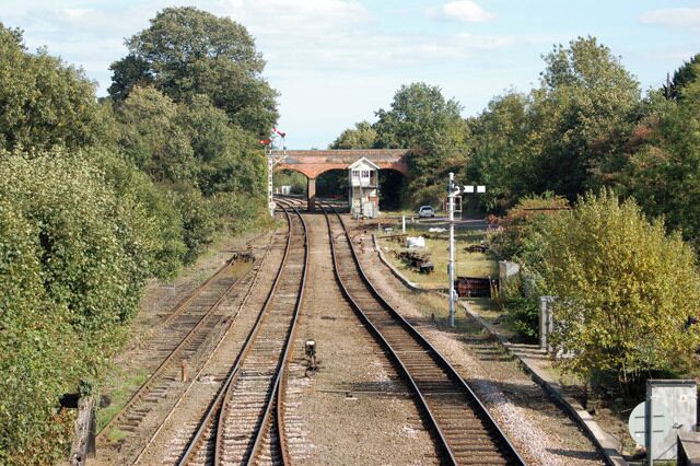 Reedham station photo-survey (8) A general view looking east - the down direction - from the road bridge spanning Reedham station (the platforms are directly below the photographer's position). This views show the up and down lines, the signal box, and the redbrick bridge carrying Witton Green. Reedham Junction is beyond the bridge; a single track route branches northeast to Yarmouth and the double track route continues southeast to Lowestoft. The junction is controlled by a traditional lever-frame in the signal box (see other photos in this series). Down traffic over the junction is controlled by the bracketed-post semaphore signal (to the left of the signal box). Note that the signal arm for the Lowestoft route is raised to the clear or 'off' position and the arm for the Yarmouth route is at the horizontal danger position. Reedham is on the ex-Great Eastern Rly route from Norwich to Lowestoft and is situated roughly mid-way between the two towns. The station has two platforms, one for up (Norwich-bound) traffic and one for down (Yarmouth and Lowestoft) traffic. The majority of passenger services are operated by National Express.