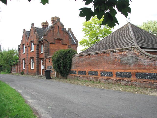 The Grange. This house is part of The Grange which adjoins St Martin's church > 1394594 in the north. New Buckenham is a village located on the Norfolk-Suffolk border. Interestingly, its street plan is still based on the old medieval grid pattern. 16th century houses, built from wattle and clay on timber frames, stand side by side with flint and brick cottages, often hidden behind Georgian and later brick facades > 1394567. The 18th century market cross, situated in the village centre, serves as a shelter > 40538. The village has two pubs, the George > 1394575 and the Kings Head, a number of local shops and a general store which is combined with a bakery and a post office > 1394579. There is a large common designated a Conservation Area to the east of the village. The remains of a castle are on the edge of the village, and near it there is the first place of worship, the now restored St Mary's Chapel, which was replaced by St Martin's church > 1394594.