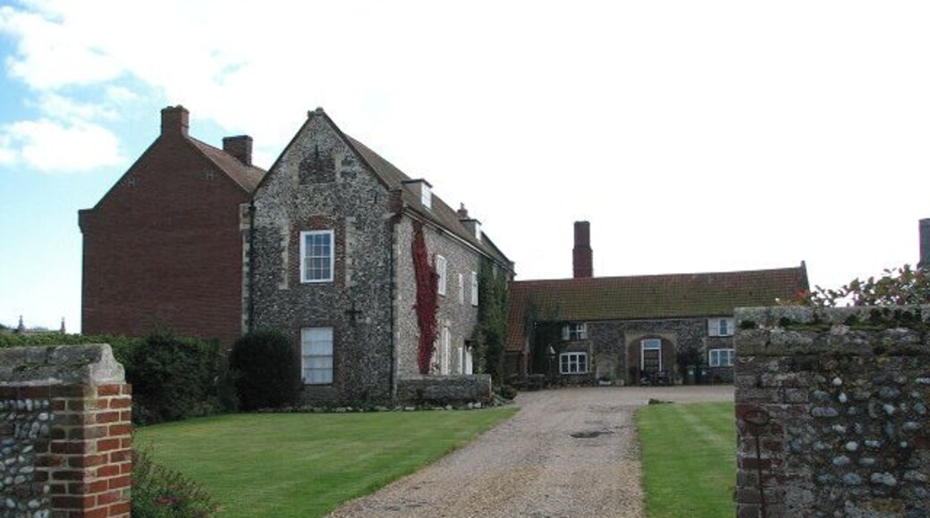 Entrance to the Hall. Waxham Hall is a 12th century manor which by the 16th century was owned by the Calthorpe family and later by the Wodehouses, who built the Hall and its enclosure, presumably before the death of Sir Thomas in 1571. The house was surrounded by a high wall entered through gateways - with tracery in the spandrels > 995305 - which originally extended outwards to include the church. The enclosing wall has polygonal angle buttress shafts which are crowned by finials. (N. Pevsner & B. Wilson, The Buildings of England, Norfolk 1, 2002)