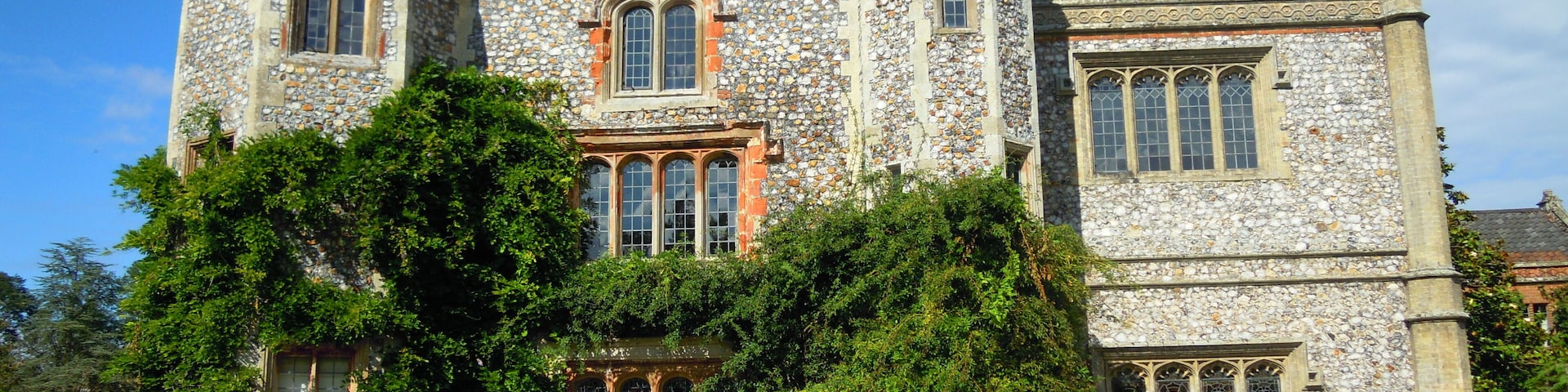 A large stone building with arched windows and a tower.
