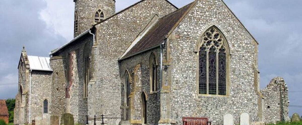 A historic stone church with a prominent tower and arched windows.