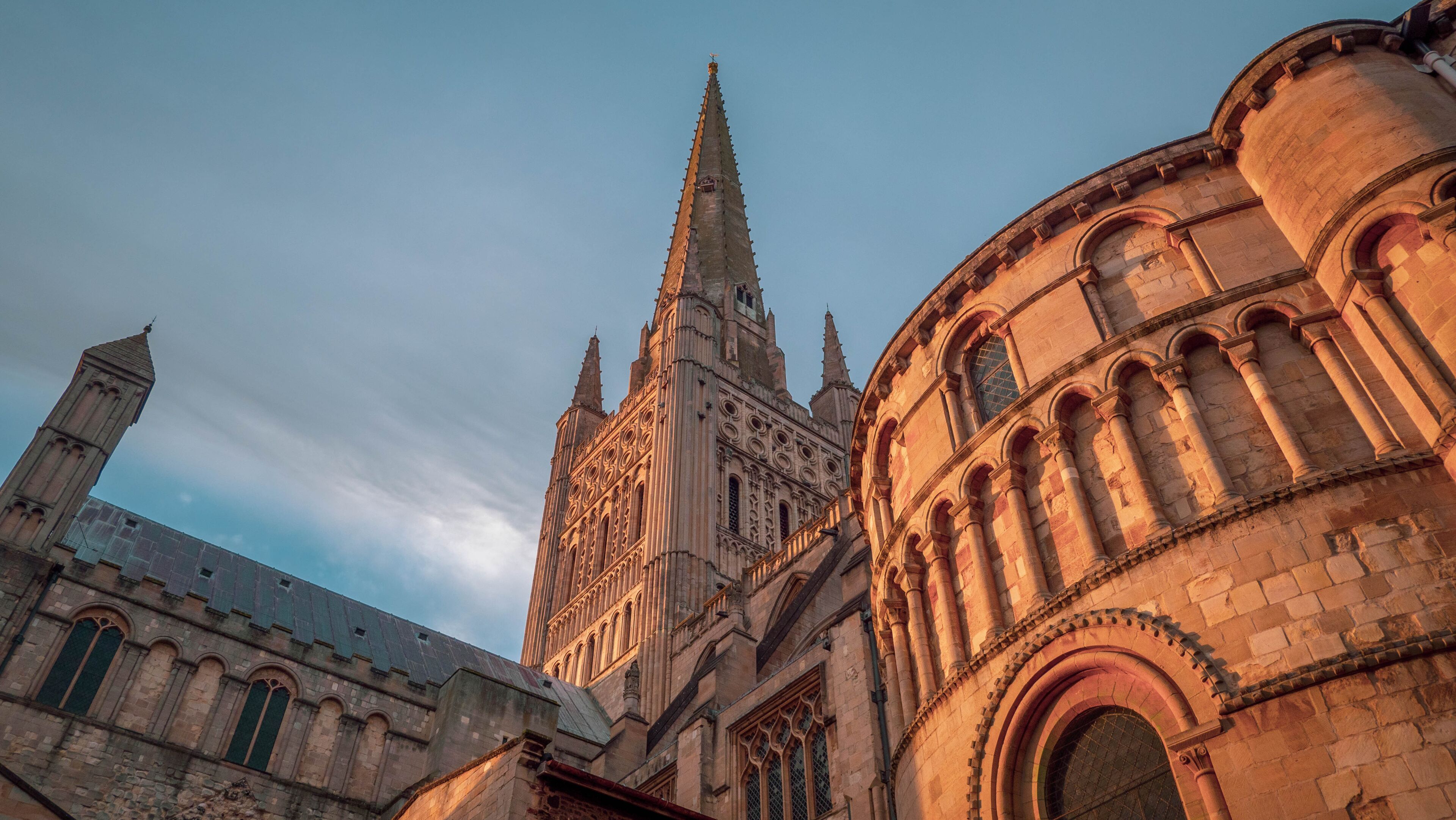 A historic cathedral with a tall spire, intricate stonework, and arched windows.