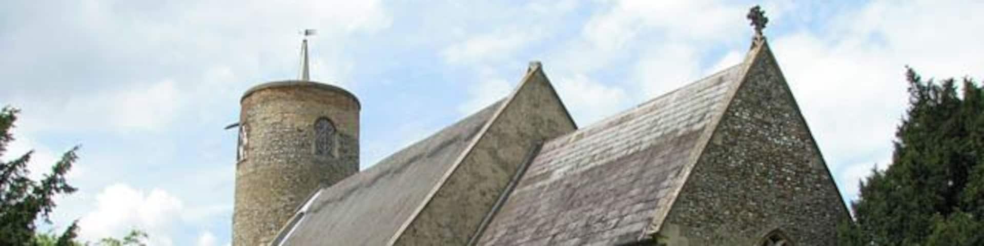 The church of SS Margaret and Remigius - viewed from the southeast. The church of Seething > 1313339 - 1454714 is dedicated to the saints Margaret and Remigius. It has an 11th century (Norman) round tower > 1313326 with the main building dating from the 14th century. The church interior retains a number of medieval wall paintings > 1454746. The benches have carved poppy heads and old glass can be seen in several of the windows. Two roundels in the nave south window depict the symbols of St Mark > 1454776 and St Luke > 1454780 and an angel holding a shield > 1454784 is inset in the chancel north window. The east window is Victorian. The south door is original as is part of the medieval flooring. The rood screen dado > 1454720 dates from the 15th century and is decorated with stencilled flowers and gessowork. The octagonal font > 1454797 is one of 40-odd existing Seven Sacrament fonts, dating from 1480. In comparison with other fonts of this type, which were defaced during the Reformation, this one is in exceptionally good condition. The church is kept locked, a key is available.