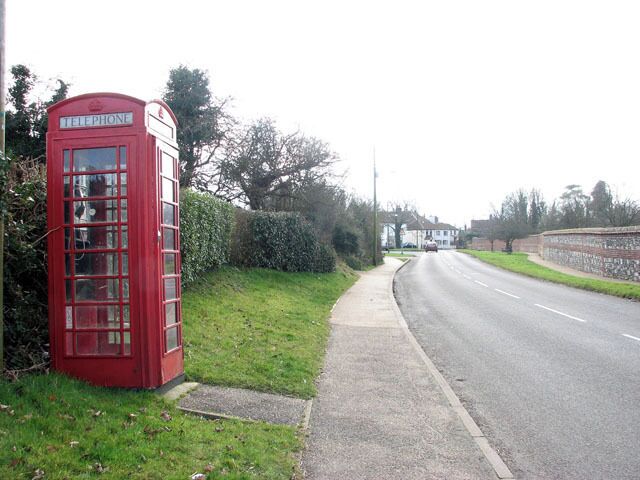 Old red telephone box This view was taken along Norwich Road in southerly direction. The brick and flint wall seen at right surrounds the 13th century priory grounds. Horsham and Newton St Faith are situated about 6 miles north of Norwich. The church of SS Mary and Andrew > https://www.geograph.org.uk/photo/1191886 located in the grounds of a ruined 13th century priory, serves both Church of England and Methodist worshippers. There are two Post Offices (one serving each village), one restaurant and two public hostelries. For more information and old photographs see http://www.st-faith.co.uk/