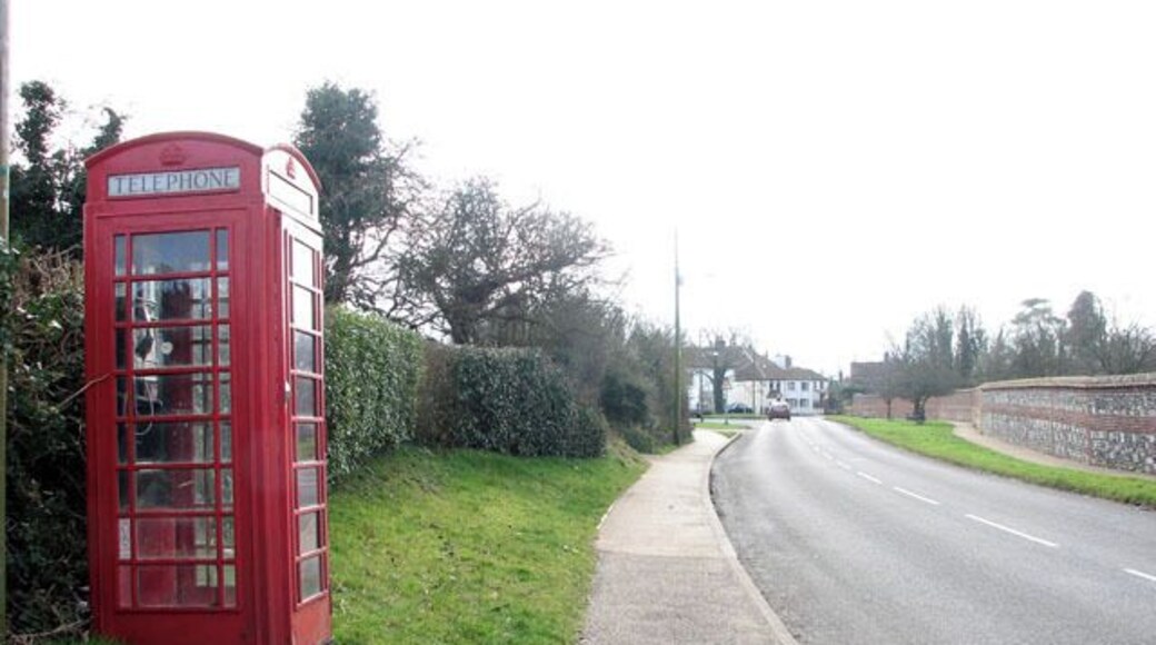 Old red telephone box This view was taken along Norwich Road in southerly direction. The brick and flint wall seen at right surrounds the 13th century priory grounds. Horsham and Newton St Faith are situated about 6 miles north of Norwich. The church of SS Mary and Andrew > https://www.geograph.org.uk/photo/1191886 located in the grounds of a ruined 13th century priory, serves both Church of England and Methodist worshippers. There are two Post Offices (one serving each village), one restaurant and two public hostelries. For more information and old photographs see http://www.st-faith.co.uk/