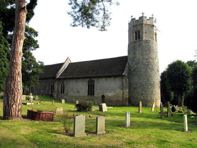 A church with a tall tower and a graveyard.