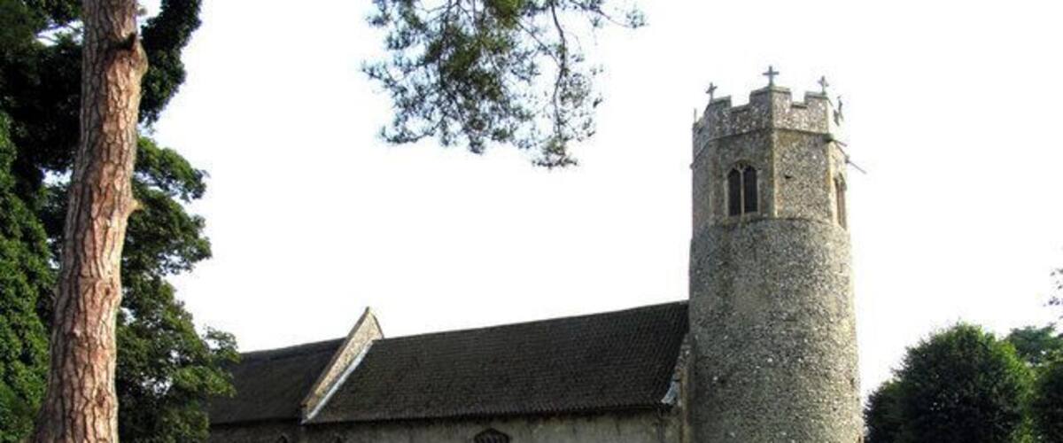 A church with a tall tower and a graveyard.