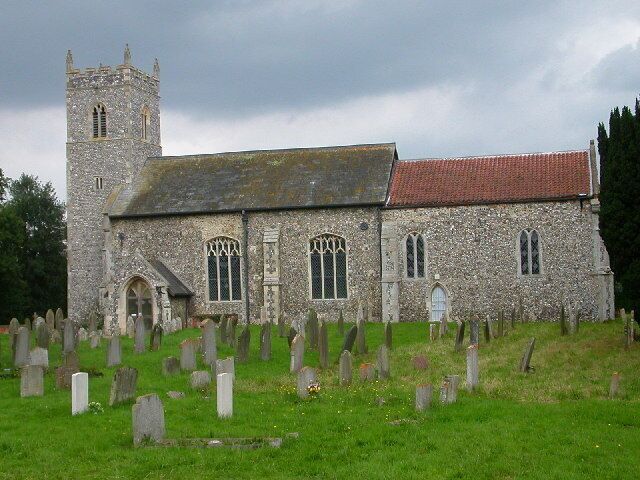 A stone church with a tower and a graveyard in front.