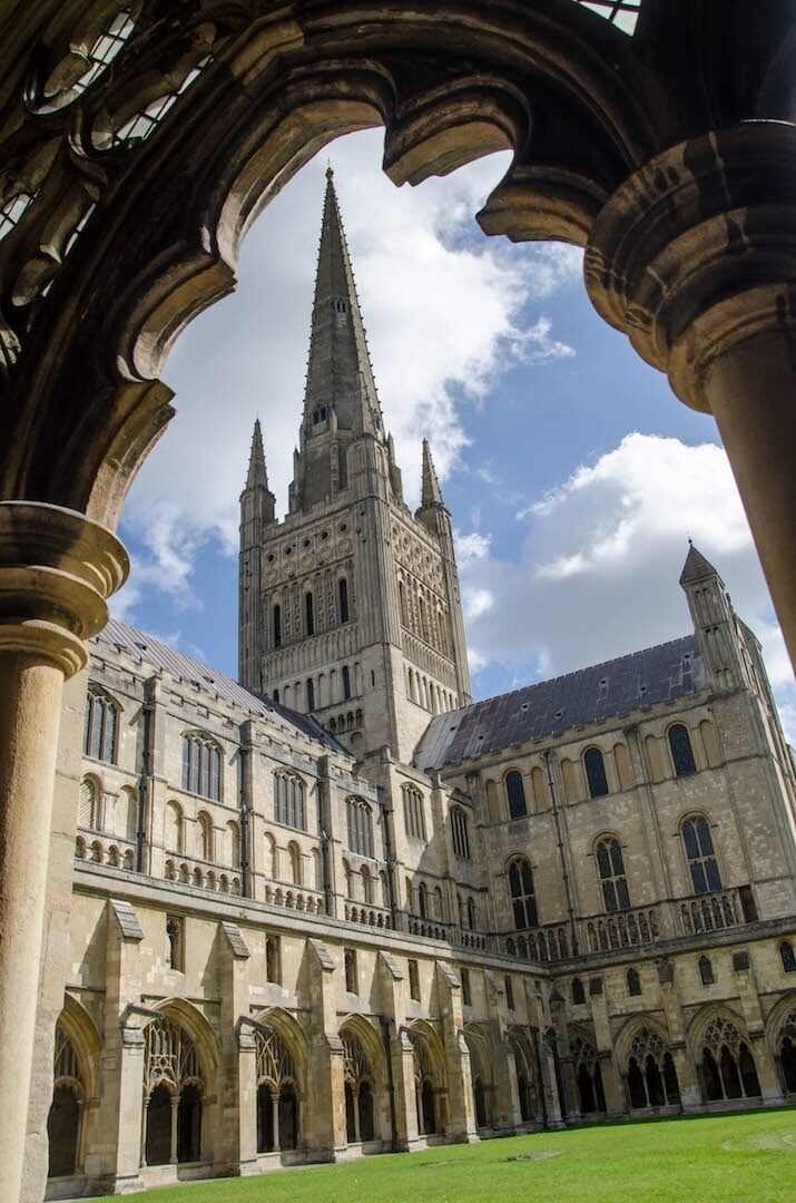 A historic building with a tall spire and arched windows.
