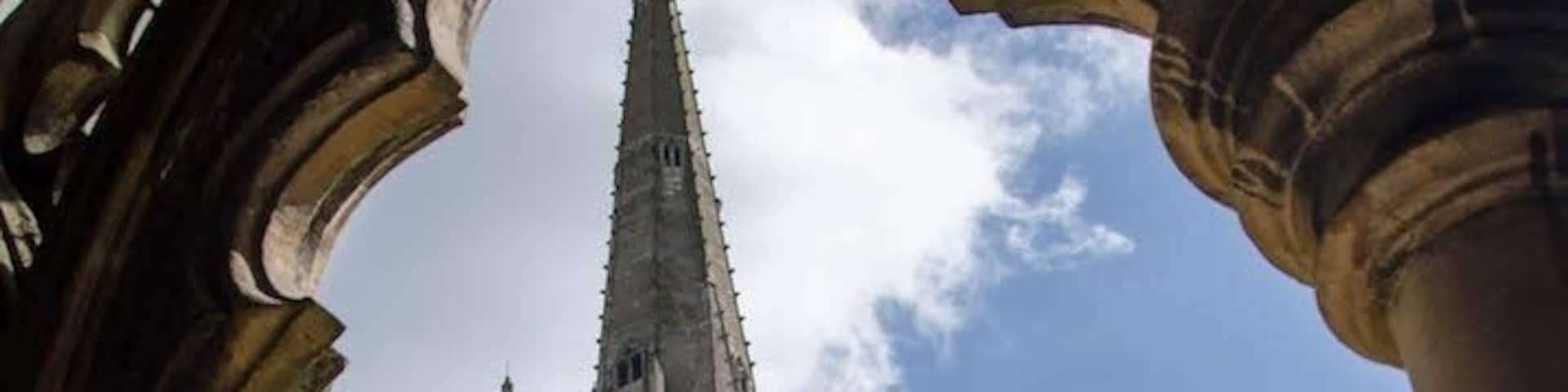Un bâtiment historique doté d’une haute flèche et de fenêtres en arc.