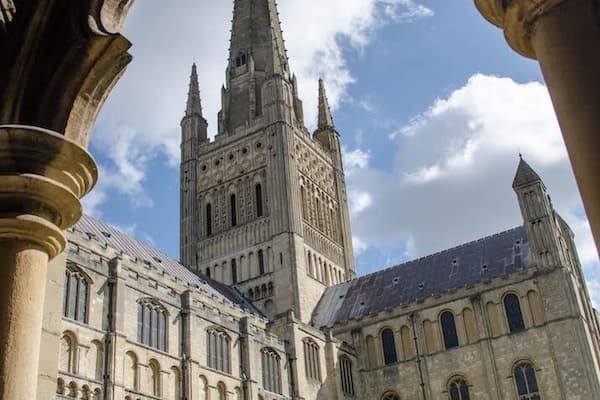 A historic building with a tall spire and arched windows.
