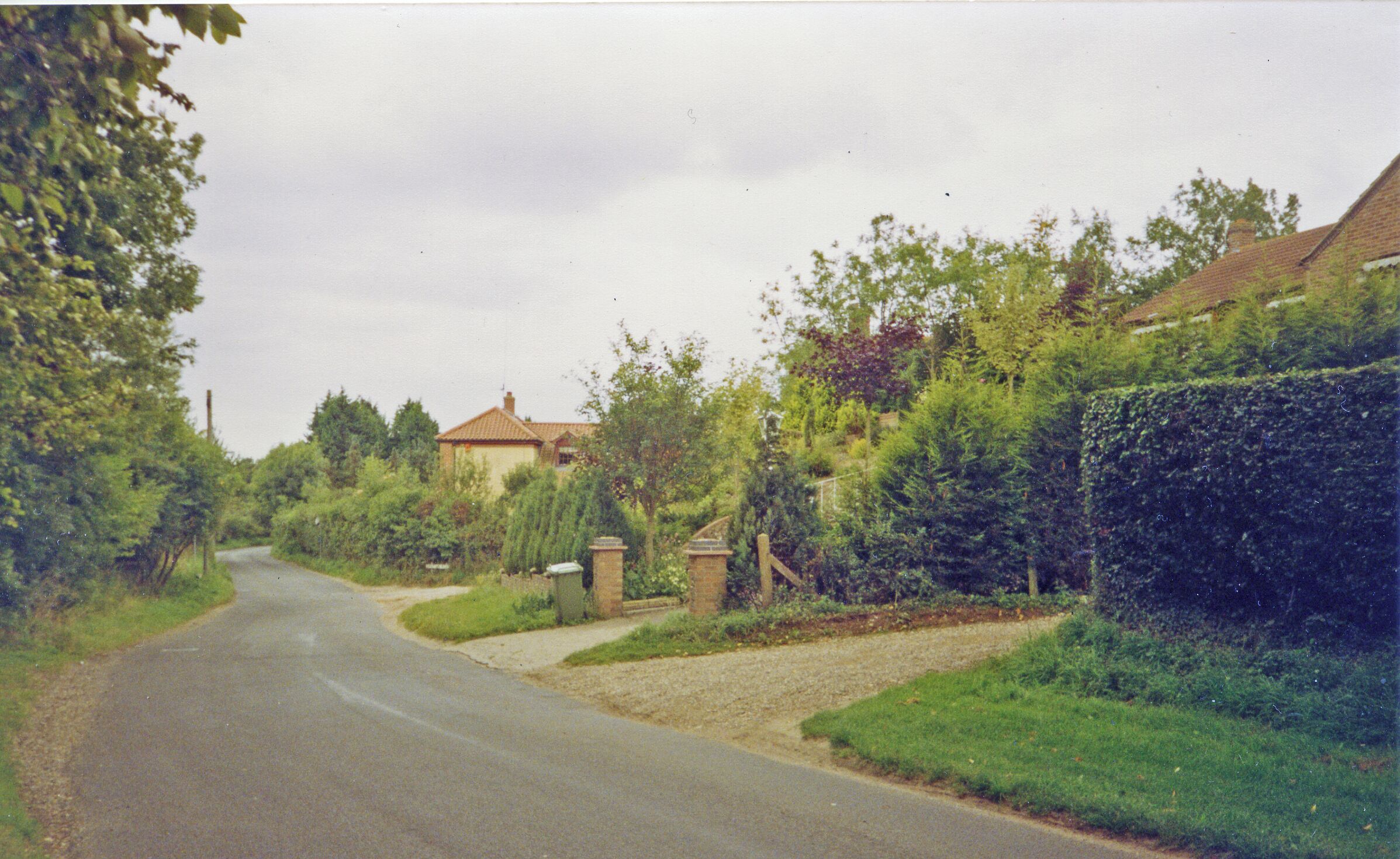 Drayton (Norfolk): near site of station, 1993. View westward on Costessey Road by Station Road: the station had been up to the right and here the ex-Midland & Great Northern branch Melton Constable (left) - Norwich City (right) had crossed here - until 2/3/59 when almost all the M&GN system was closed wholesale.