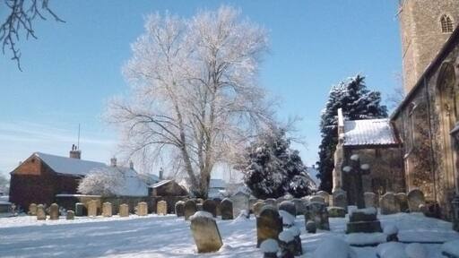Part of St Margaret's parish churchyard, Lyng, Norfolk, England, in snow in January 2013