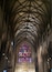 Interior de uma catedral em estilo gótico, com teto abobadado alto e vitrais.