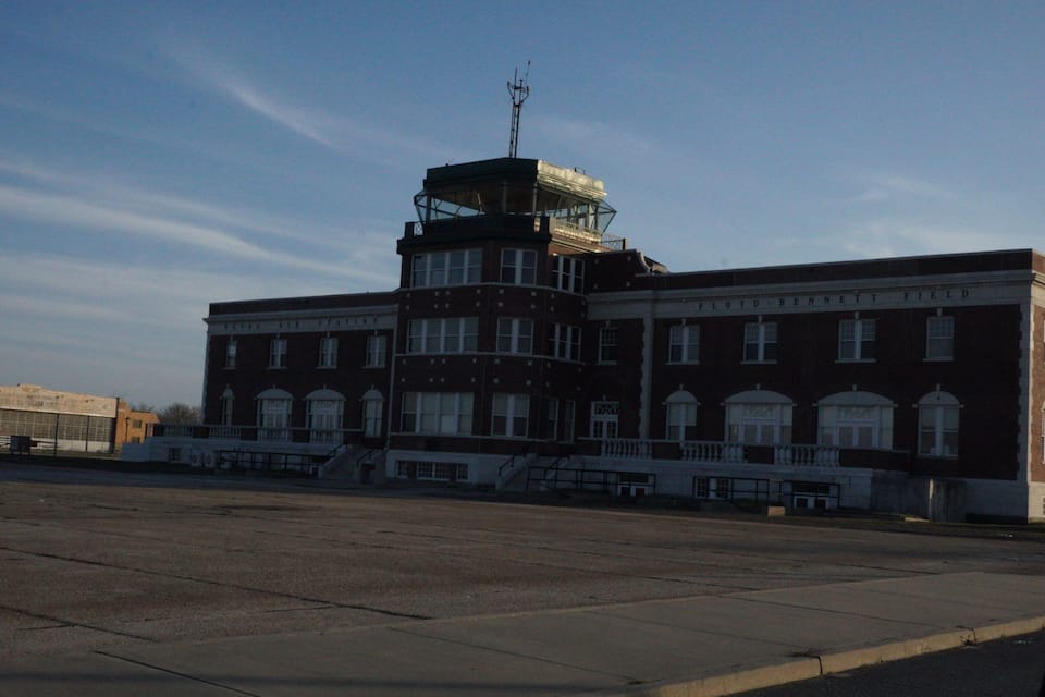 A large brick building with a tower and a sign that reads "Floyd-Bennett Field".