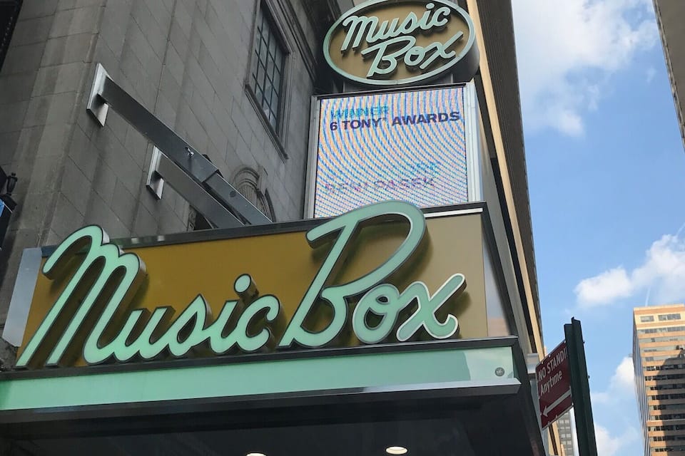 Een gebouw met een 'Music Box' bord en een 'Winnaar Beste Musical' onderscheiding.