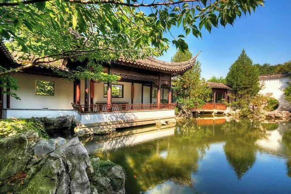 A traditional Chinese building with a pond in front.