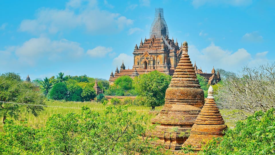 A large, ancient temple complex with tiered pagodas and a prominent stupa.