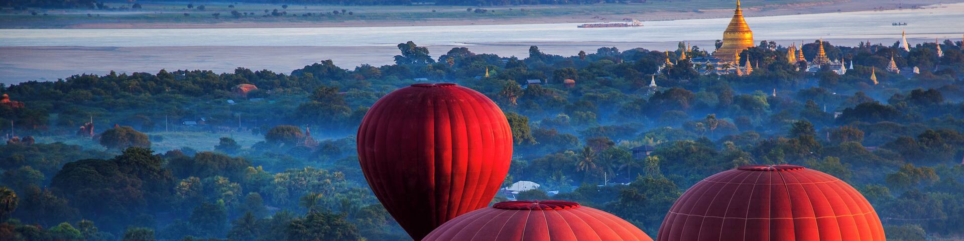 Red hot air balloons over jungle, Nyaung-U, Mandalay Region, Myanmar