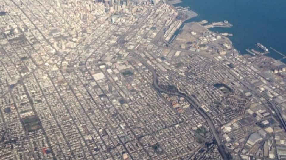 An aerial shot showing San Francisco, the Bay Bridge, and The Twin Peaks at the bottom of the photo.