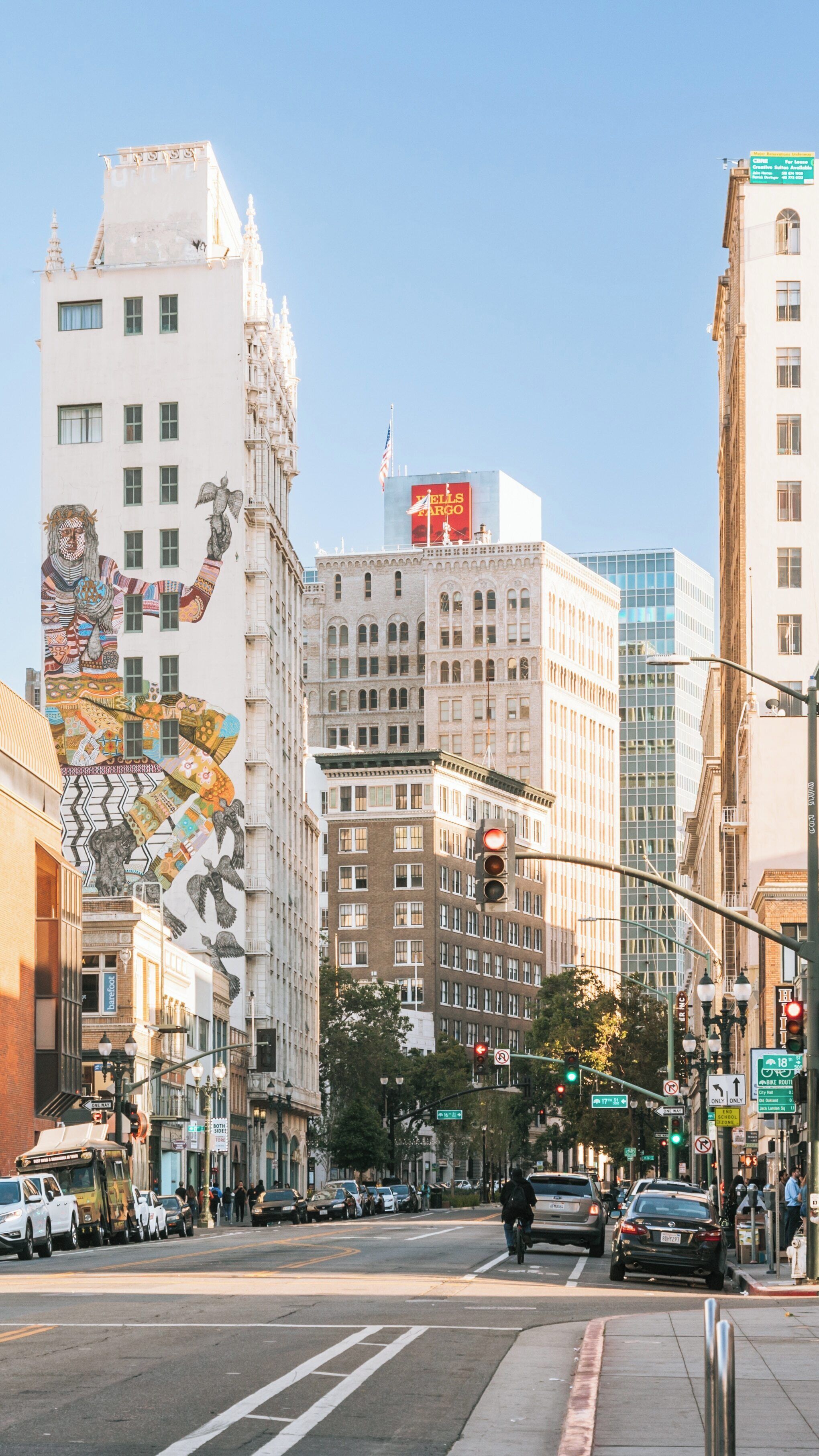 Vibrant afternoon on Telegraph Avenue showcasing urban life in Elmwood, Oakland, California with striking murals and bustling streets