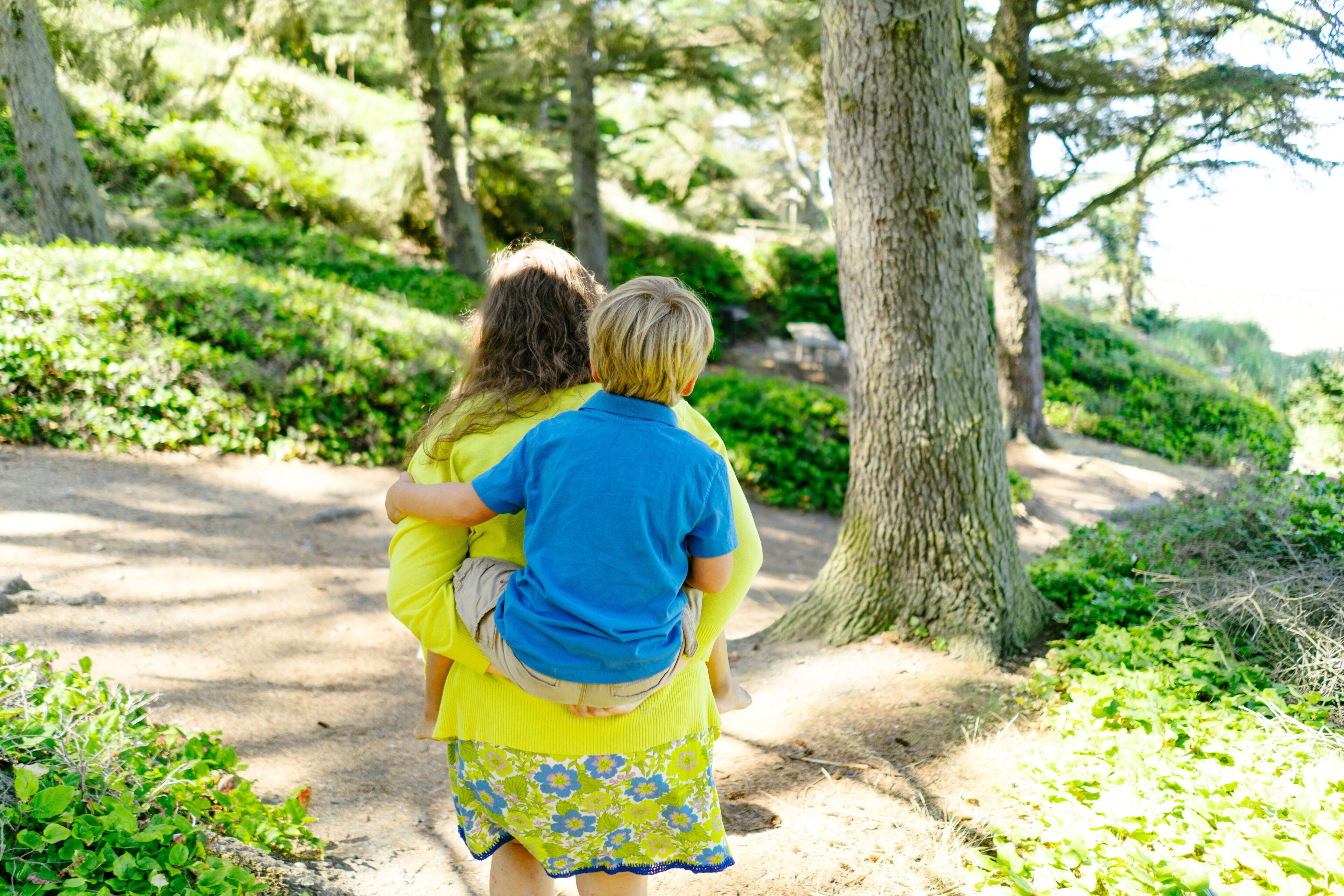 Rear view of mother piggybacking son while walking at Fort Ebey State Park