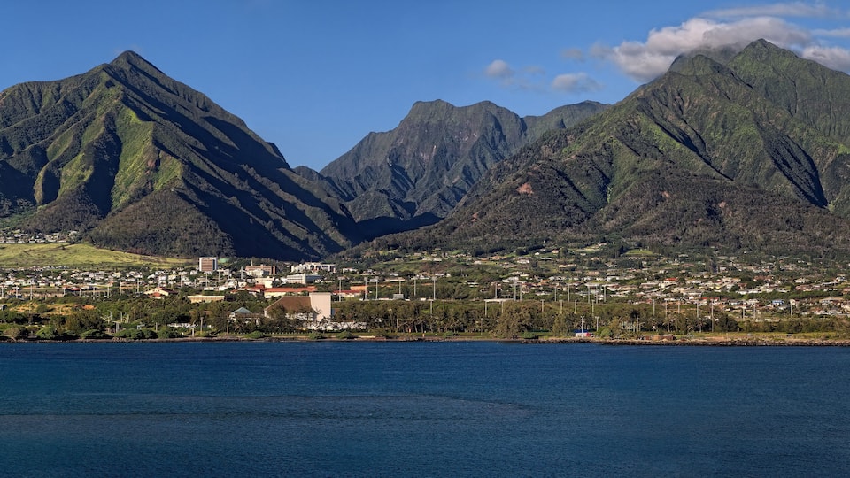 A coastal town with mountains in the background.