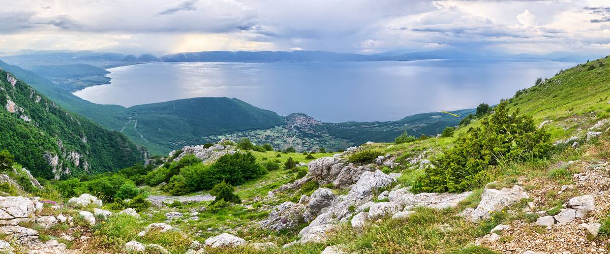 A mountainous landscape with a lake and a small settlement.