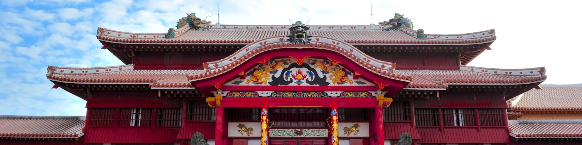 Un edificio tradicional de color rojo con decoraciones elaboradas y una entrada amplia.