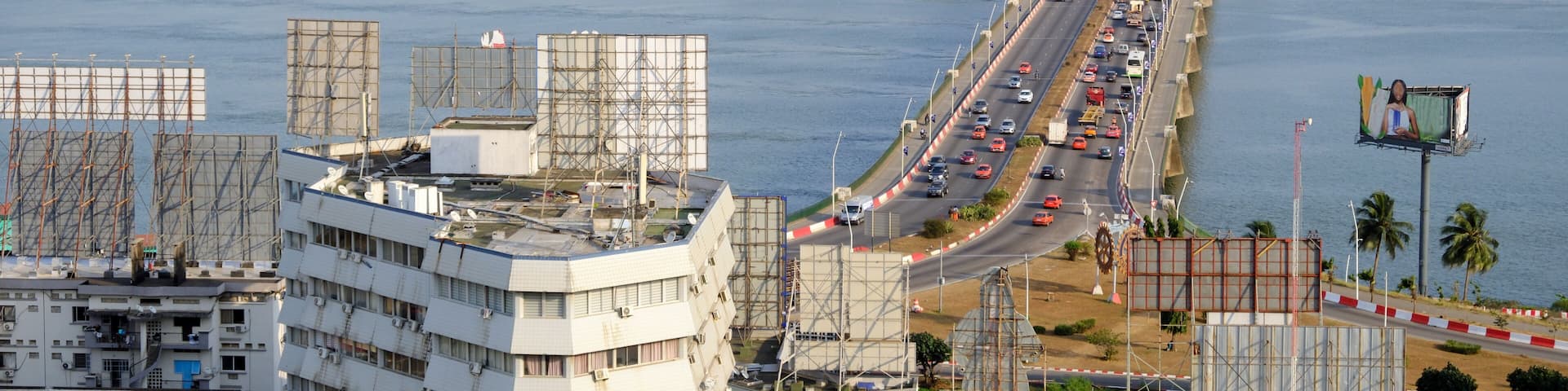 A bridge over water with a cityscape in the background.
