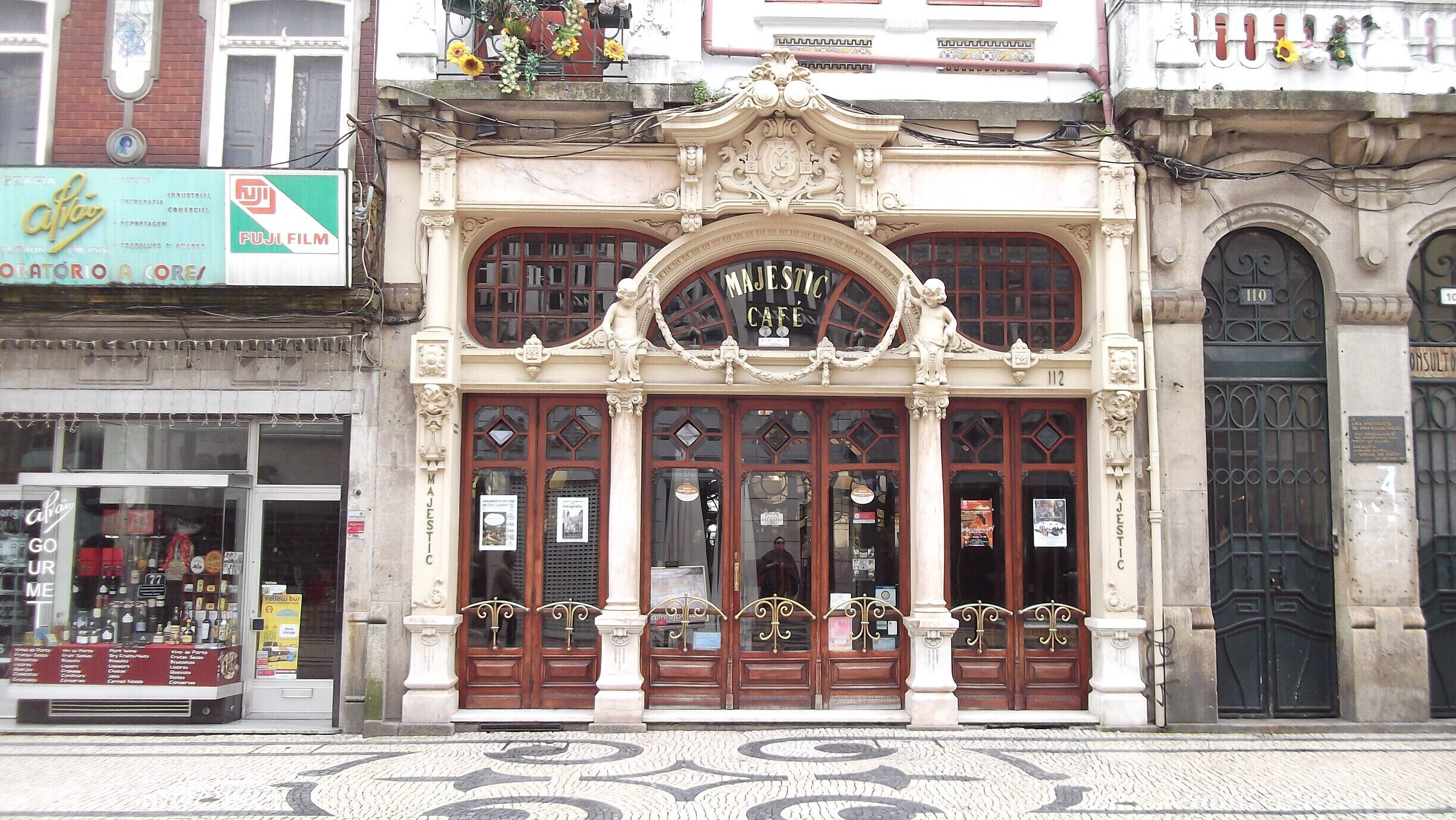 Un edificio histórico con arquitectura ornamentada, que incluye una gran entrada en arco y columnas decorativas.