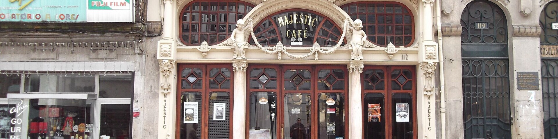 Un edificio histórico con arquitectura ornamentada, que incluye una gran entrada en arco y columnas decorativas.