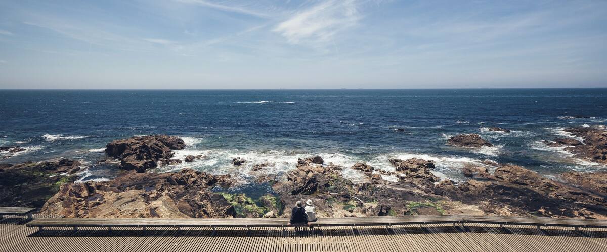 Elderly couple sitting in  front of the atlantic ocean and blue sky.
#porto #BVSBlue #portugal #atlanticocean
