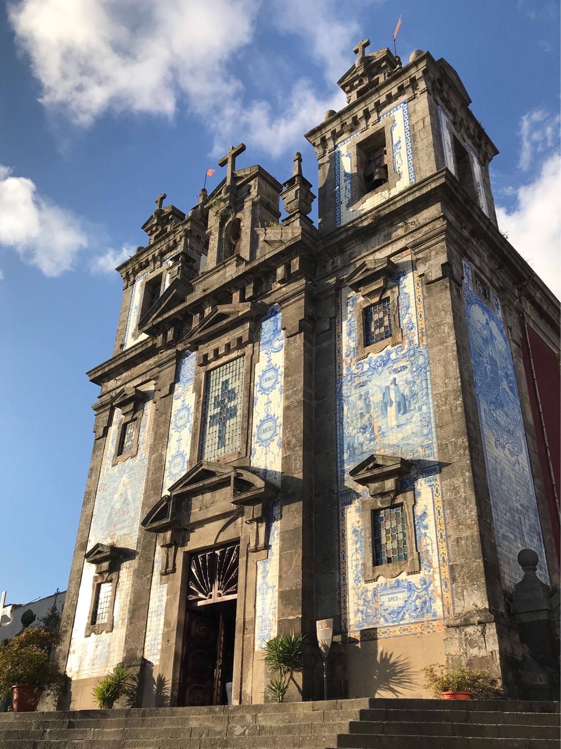 A historic building with blue and white tiled facade, ornate architectural details, and a clock tower.