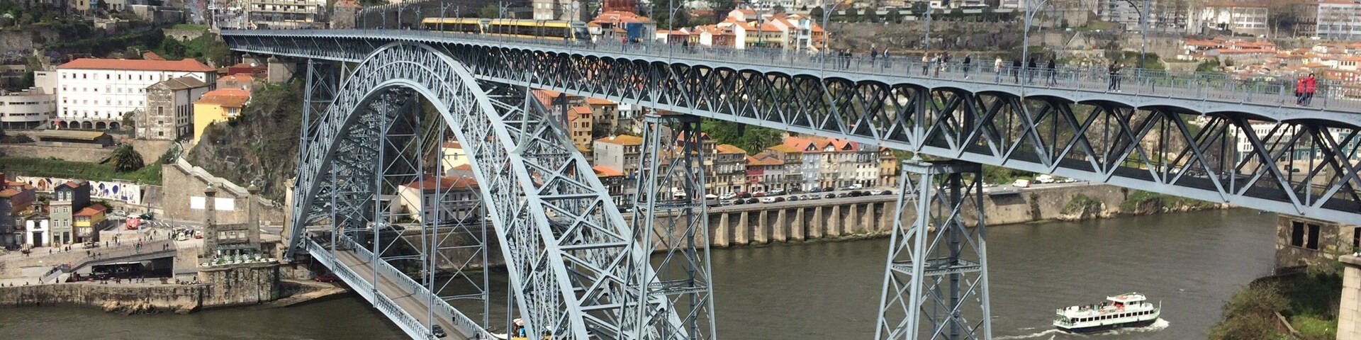 A seagull swoops down over the Dom Luís bridge. A double-deck metal arch bridge that spans the River Douro between the cities of Porto and Vila Nova de Gaia in Portugal.