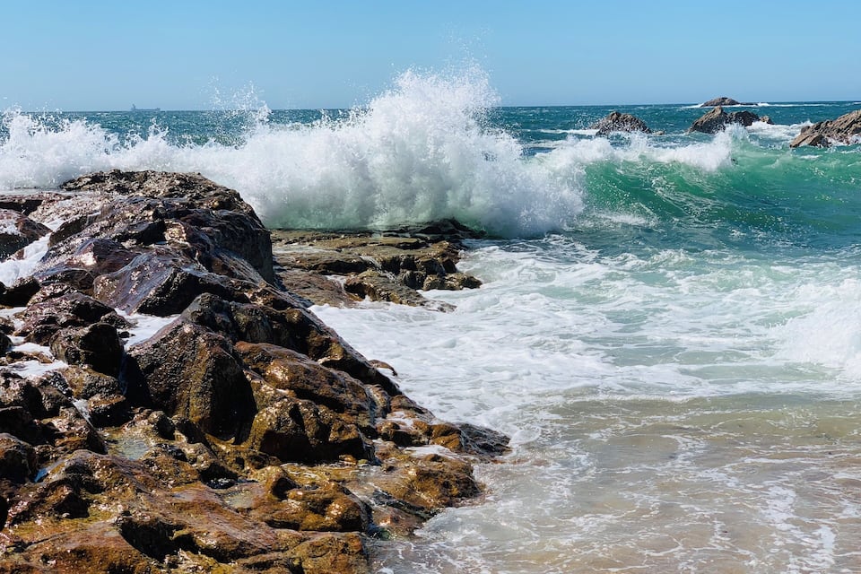 A rocky shoreline with waves crashing against the rocks.