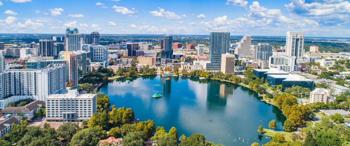 A cityscape with a large lake surrounded by buildings and greenery.
