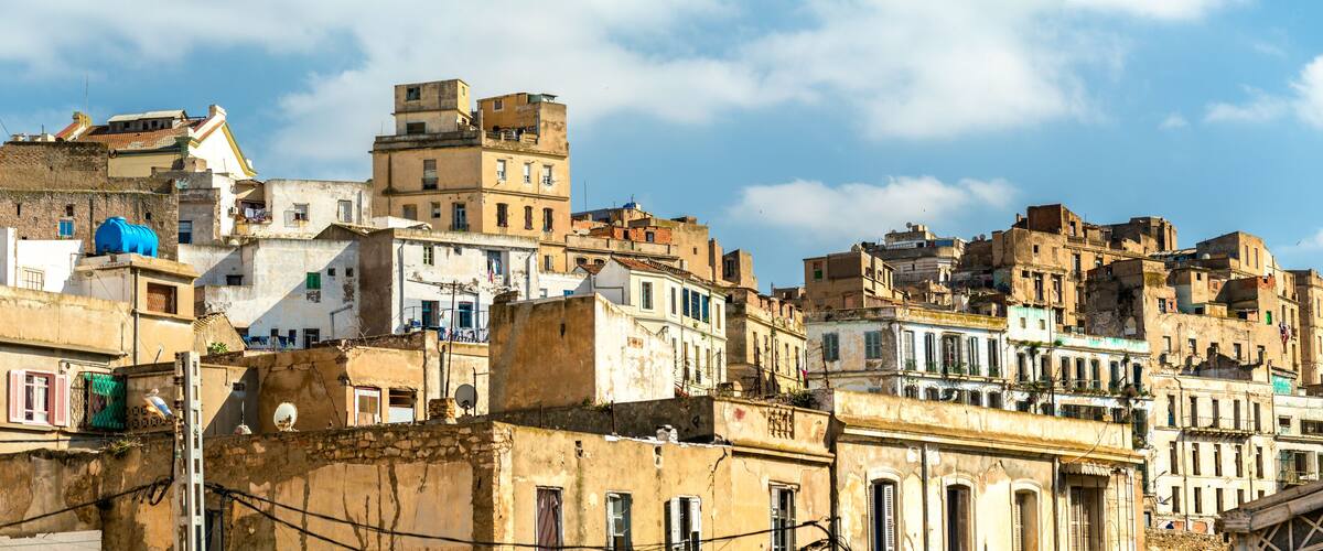 A densely packed urban area with historic buildings and a clear blue sky.