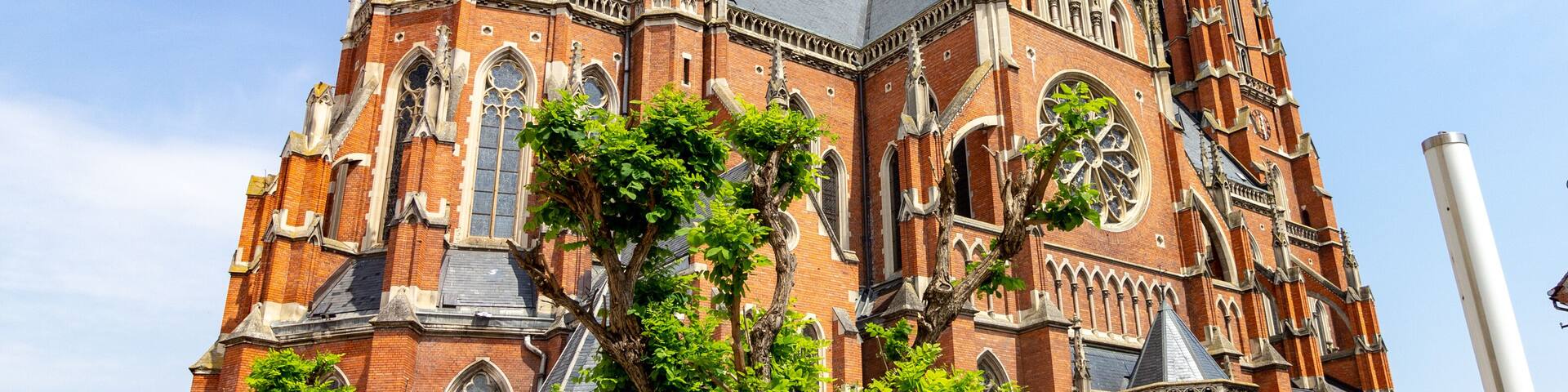 A large, ornate brick church with multiple spires and a prominent clock tower.