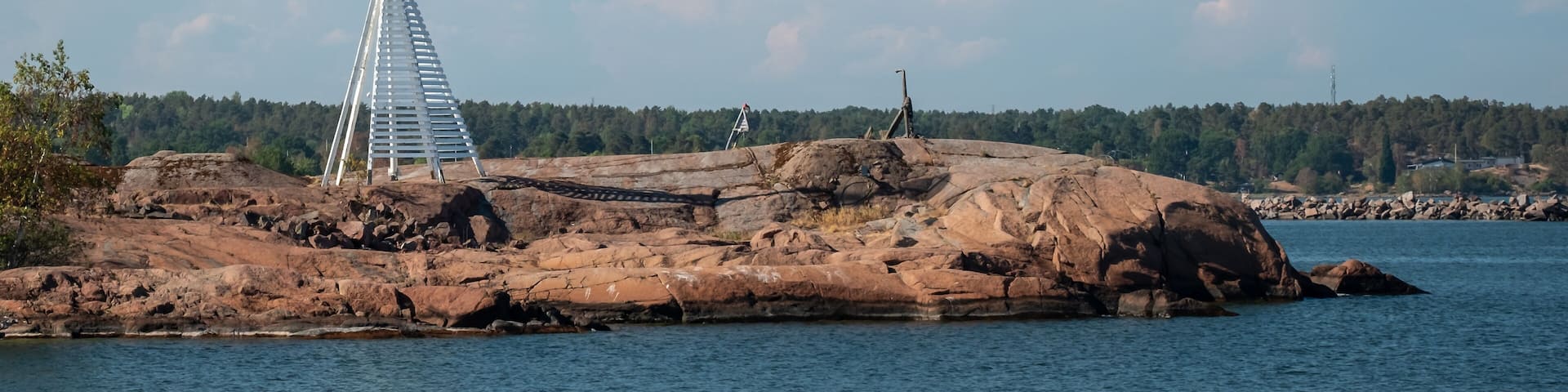 A rocky island with a metal structure and a flagpole.