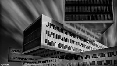 A modern building with a geometric facade and a large overhanging section.