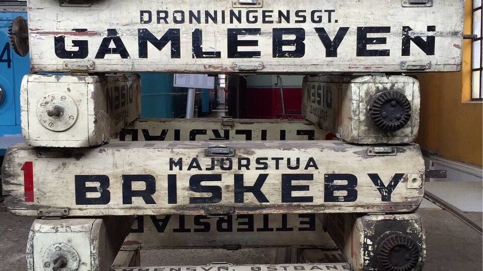 A stack of shipping containers labeled with various Norwegian cities.